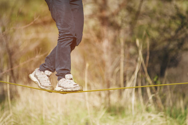 istock Slacklining is a practice of balancing, in which nylon or polyester fabric stretched between two anchor points is commonly used. People walk on it and do tricks 686597906