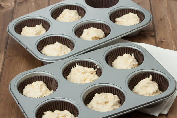 istock Baking Trays With Raw Muffin Dough In Paper Cases. 686600650