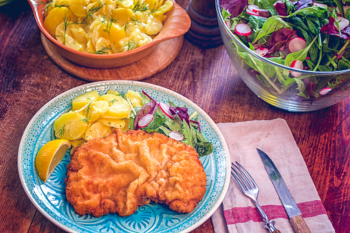 Wiener Schnitzel with Potatoes and Green Salad served on a plate