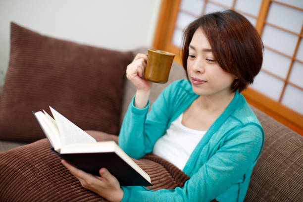 istock Asian woman reading coffee on the couch 686637074