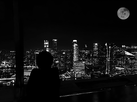 Lonely Night in the Big City.Focus on foreground with blur background on Black and white.Full moon image furnished by NASA.