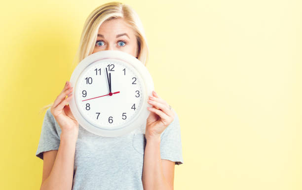 istock Woman holding clock showing nearly 12 686664334