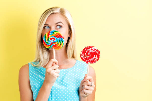 istock Young woman holding lollipops 686666618