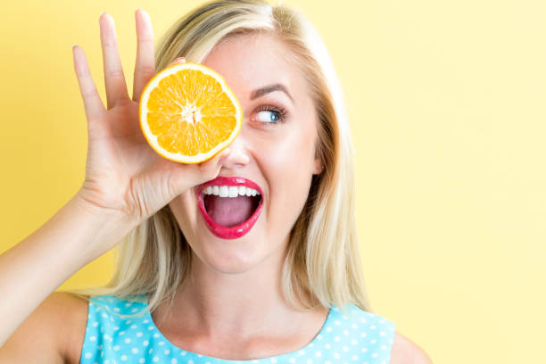 istock Happy young woman holding oranges halves 686666636