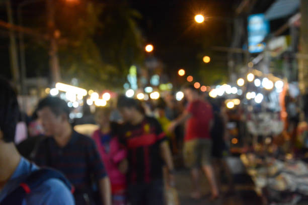 istock Blurred image of people walking in market at night 686679664