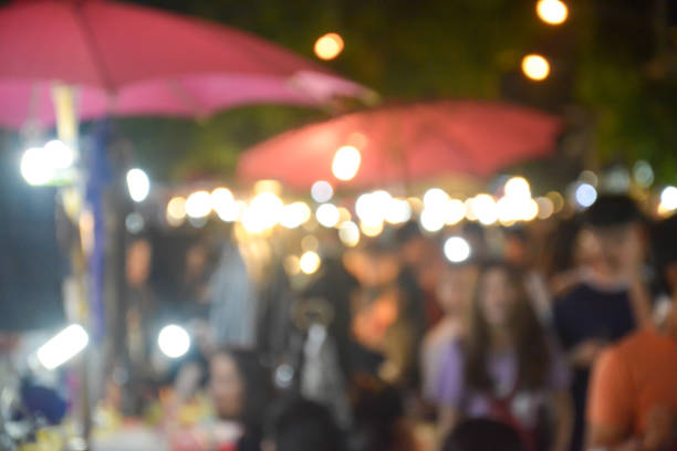 istock Blurred image of people walking in market at night 686681078