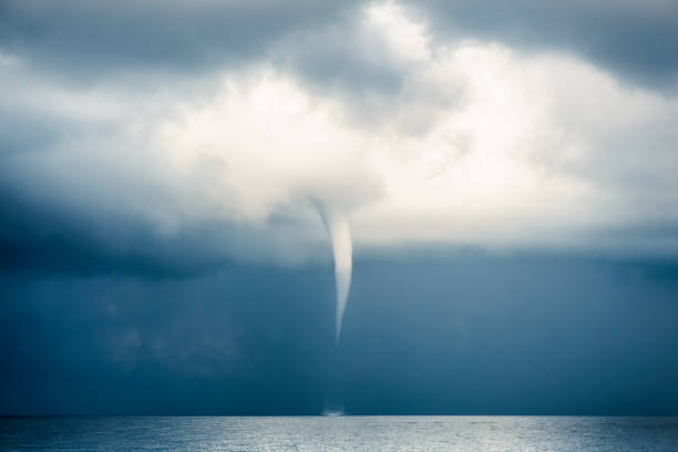 The waterspout of a tropical Tornado (aka Hurricane, Cyclone, Typhoon) is moving rapidly across the Andaman Sea, Thailand.  Numerous Cumulus, or Cumulonimbus, clouds are rising to form a deep, moody sky.  These are strong rising clouds formed by rising atmospheric vapour, that are typically associated with Thunder Storms.  The location is Ko Lanta, Krabi, Thailand, during Summer which is Monsoon Season. (Nominated for Signature+).