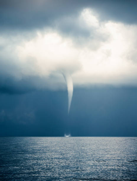 The waterspout of a tropical Tornado (aka Hurricane, Cyclone, Typhoon) is moving rapidly across the Andaman Sea, Thailand.  Numerous Cumulus, or Cumulonimbus, clouds are rising to form a deep, moody sky.  These are strong rising clouds formed by rising atmospheric vapour, that are typically associated with Thunder Storms.  The location is Ko Lanta, Krabi, Thailand, during Summer which is Monsoon Season.  (Nominated for Signature+).