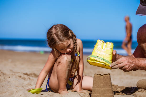 istock Little Girl Playing on the Beach with her Dady 686712390
