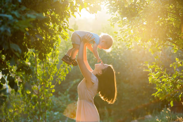 Happy young mother playing with her littlte baby son stock photo