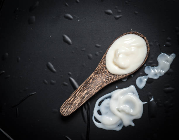 istock Wooden spoon with milk cream on a black slate 686717226