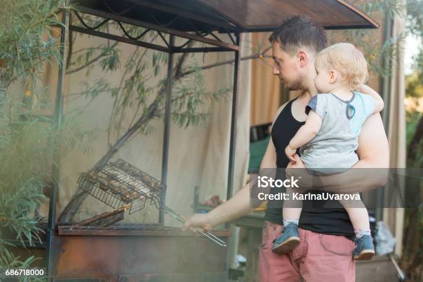 Father And Son At Barbecue Grill In Park Stock Photo - Download Image Now - Barbecue - Meal, Barbecue Grill, Baby - Human Age