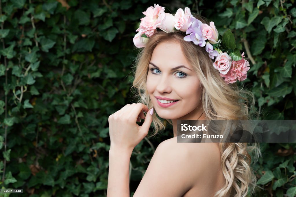 Jovem fêmea na coroa de flores sobre fundo verde natural - Foto de stock de Adulto royalty-free