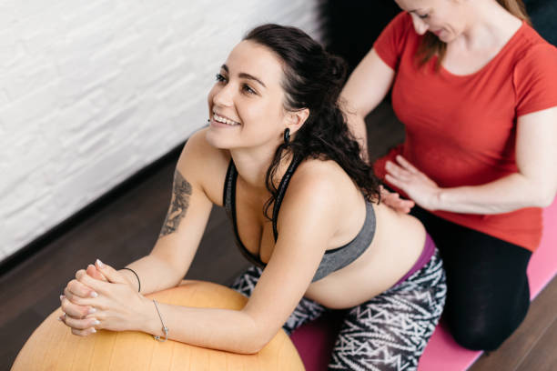A pregnant woman enjoying a back massage from her midwife stock photo