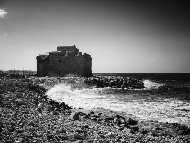 Sand castle on the beach reflected in sea water. Black and white photography.