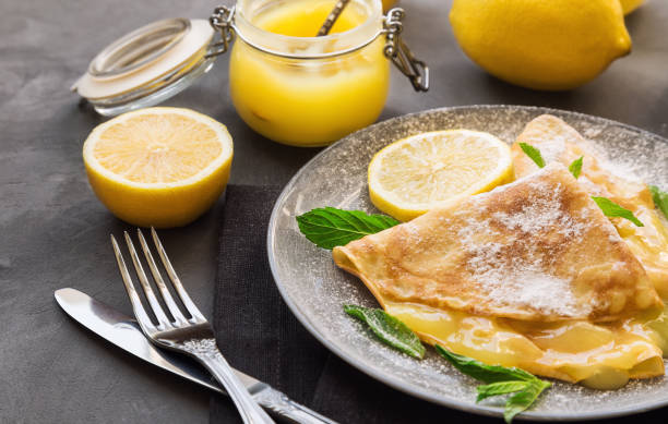 istock Fresh homemade crepes with lemon curd on gray concrete background. 686731436
