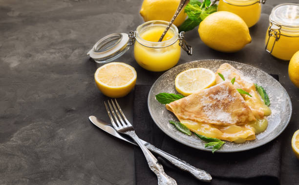 istock Fresh homemade crepes with lemon curd on gray concrete background. 686731456