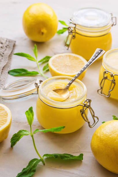 istock Fresh homemade lemon curd in glass jars on light concrete background. 686731472