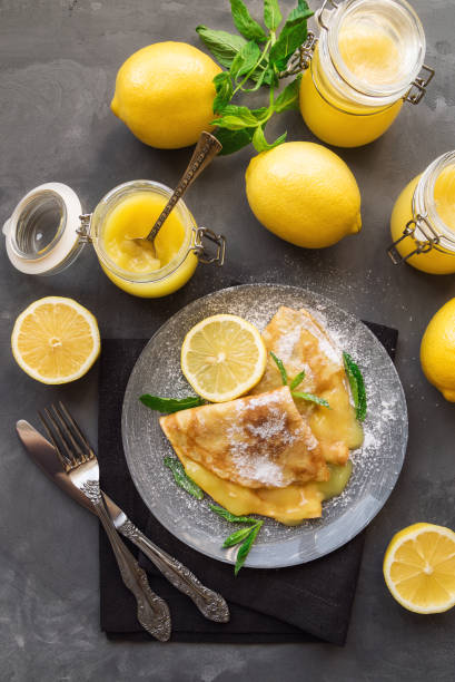 istock Fresh homemade crepes with lemon curd on gray concrete background. 686731476