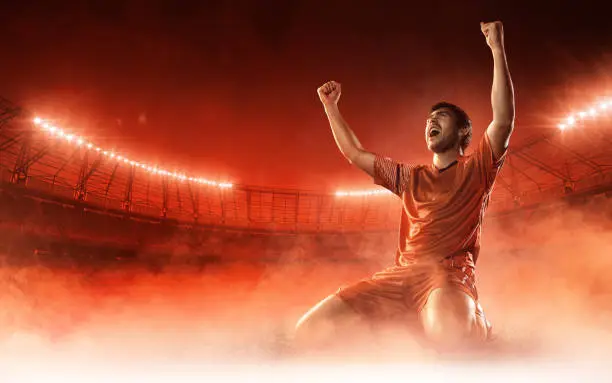 soccer player celebrating a goal on red smoke background