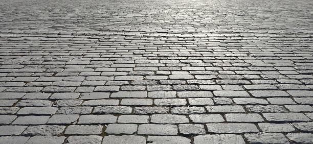 Abstract background of old cobblestone pavement close-up.