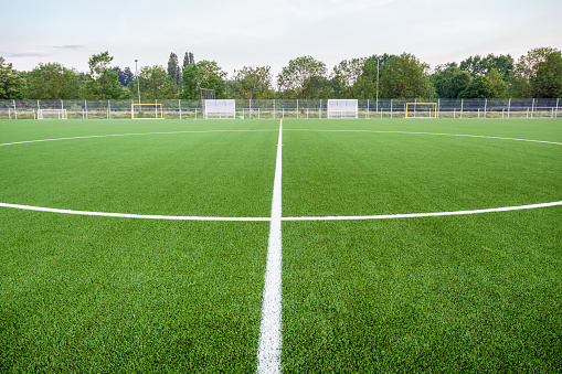 An football field with artificial turf and white linesAn football field with artificial turf and white lines