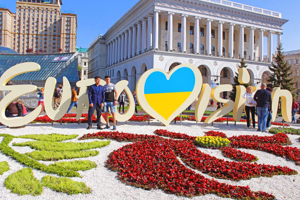 Unidentified tourists near part of official logo of Eurovision Song Contest 2017 on Maidan Nezalezhnosti (Independence Square) stock photo