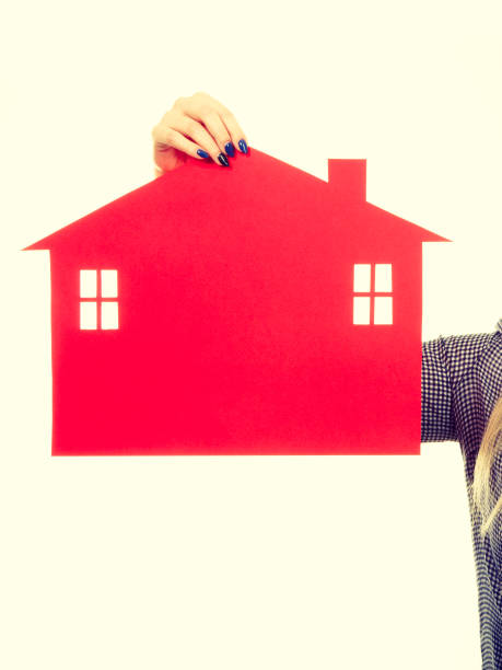 istock Female hand holding red paper house symbol 686743524