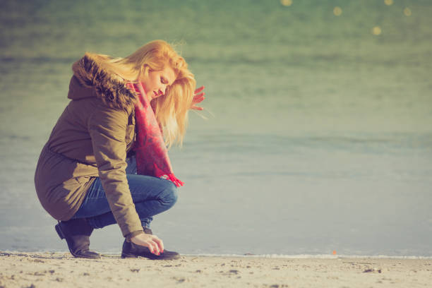 istock Woman relaxing on beach, cold day 686743674