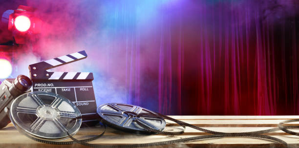 Film movie Background - Clapperboard And Film Reels In Theatre Film Slate And Rolls Of Filmstreep And Spotlights stage theater photos stock pictures, royalty-free photos & images