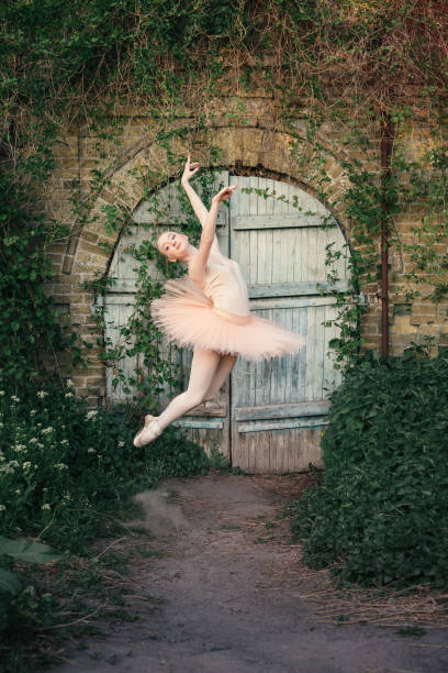 istock Ballerina dancing outdoors classic ballet poses in urban background 686753502