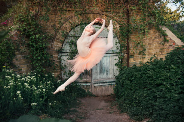 istock Ballerina dancing outdoors classic ballet poses in urban background 686753628