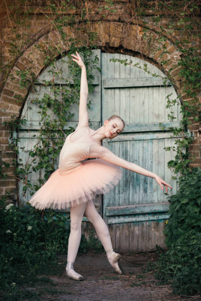 istock Ballerina dancing outdoors classic ballet poses in urban background 686756210