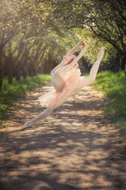 istock Ballerina dancing outdoors and jumping high into the air 686759210