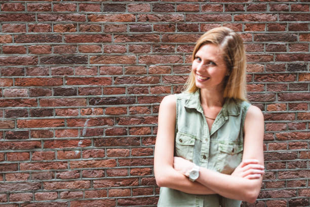 istock blonde woman portrait against a brick wall 686771136