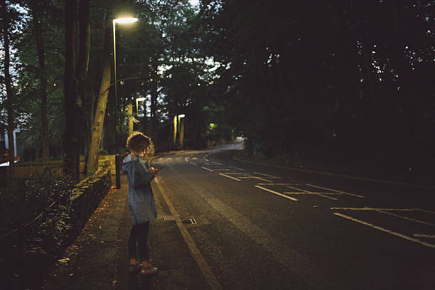 istock Side View Of Young Woman Using Phone On Road During Dusk 686792247