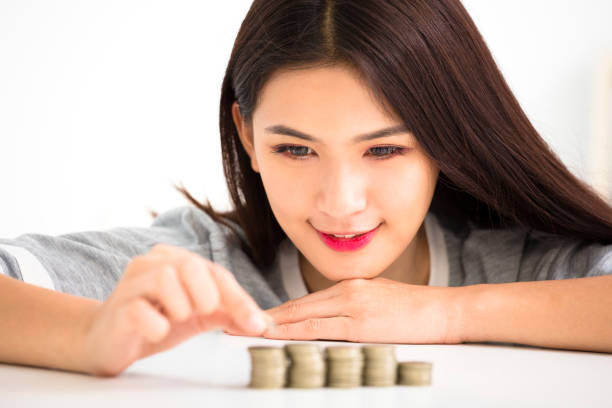 istock young woman put coins to stack , Saving money concept 686797654