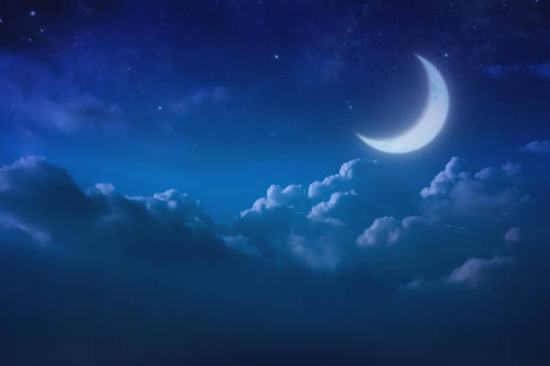 istock half blue moon behind cloudy on sky and star at night. Outdoors at night. lunar shine moonlight over cloud at nighttime with copy space background for headline text and graphic design. 686803314