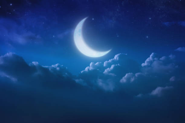 istock half blue moon behind cloudy on sky and star at night. Outdoors at night. lunar shine moonlight over cloud at nighttime with copy space background for headline text and graphic design. 686803334
