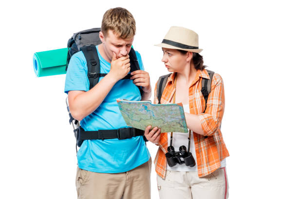 istock Thoughtful lost tourists looking at a map on a white background 686805668