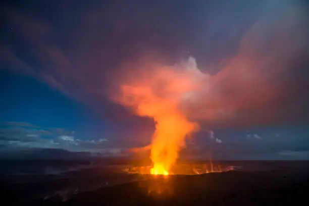 A 30-second captures the glowing lava lake in the caldera of Hawaii's Kilauea Volcano as it bounces light off of the haze drifting by in the sky.