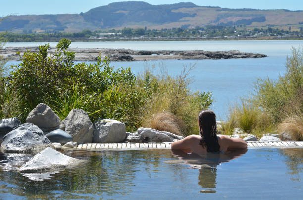Young woman having a spa Young woman having a spa in outdoors hot pool in Rotorua, New Zealand. geothermal reserve stock pictures, royalty-free photos & images