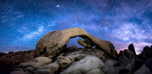 The Milky Way formed over Joshua Tree's Arch Rock.  This is a panoramic perspective requiring eight stitched images to get a 180-degree perspective.
