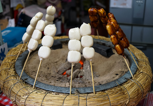 Fresh traditional charcoal grilled white mochi dumpling on stick with special sauce, Miyazaki, Japan