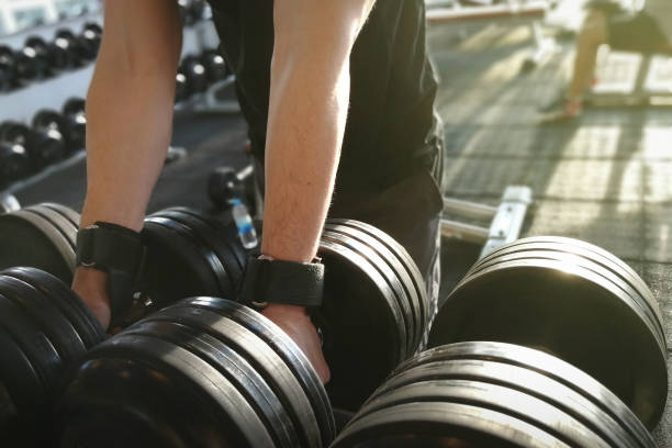 istock Male 's hand is holding metal dumbbells. 686866710