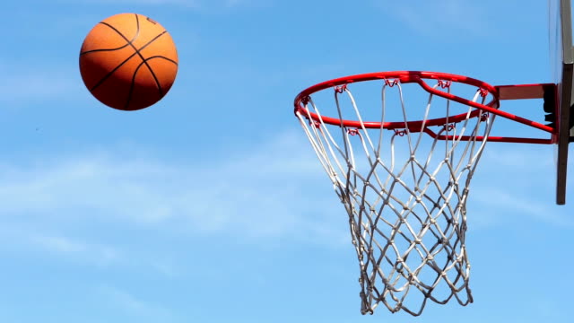 Scoring a basket in a basketball hoop. Slow motion footage.