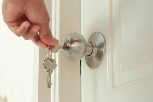 istock Hand use the key for unlocking the white door 686870032