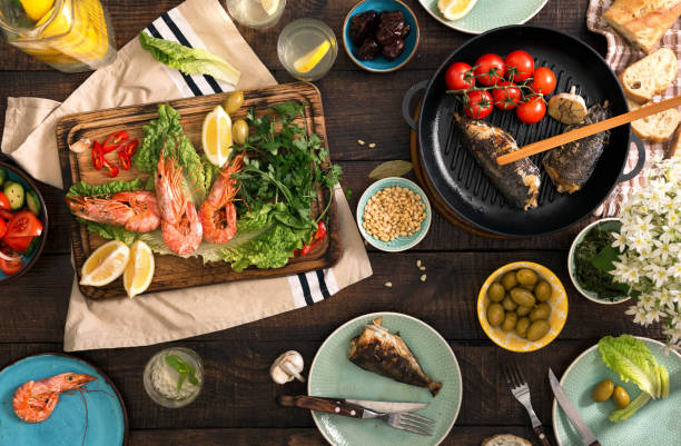 istock Dinner table with shrimp, fish grilled, salad, different snacks and homemade lemonade 686873518