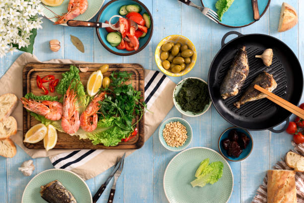 istock family dinner table with shrimp, fish grilled, salad, different snacks 686873522