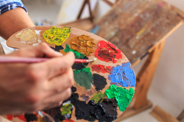 istock Close-up of artists holding multicolored palette 686873574
